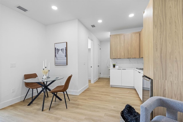 kitchen with light countertops, light wood-type flooring, modern cabinets, and visible vents