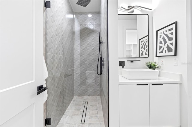 bathroom with a shower stall and vanity