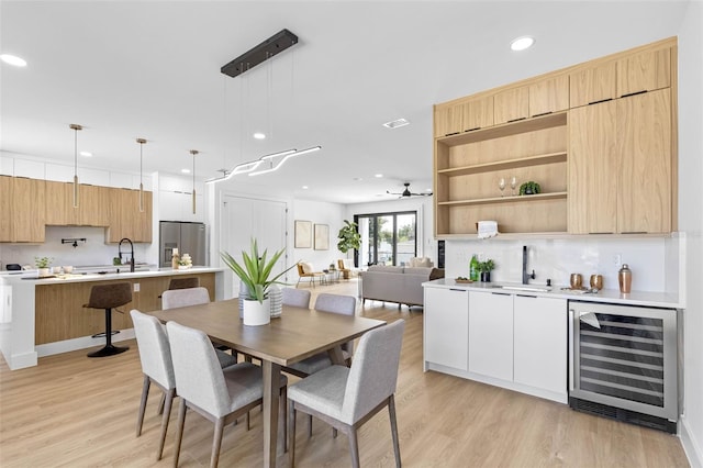 dining space with ceiling fan, light wood-style flooring, recessed lighting, beverage cooler, and visible vents