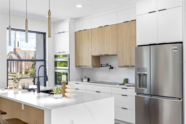 kitchen featuring stainless steel appliances, modern cabinets, a sink, and white cabinets