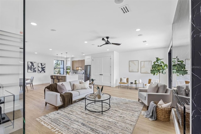 living room with light wood-style floors, recessed lighting, and visible vents