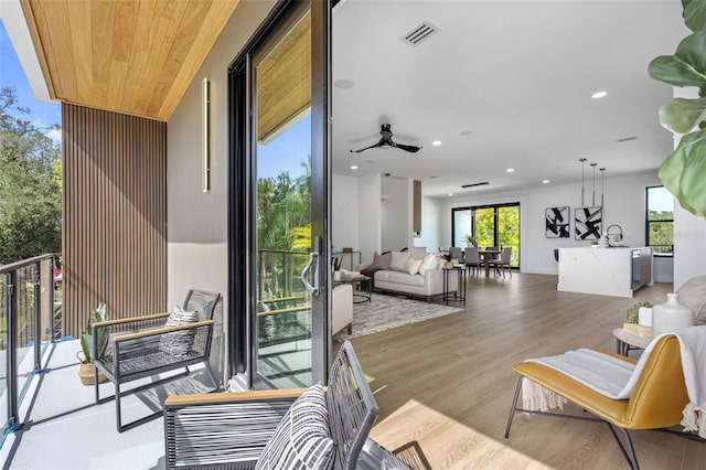 balcony with outdoor dining area, visible vents, ceiling fan, and outdoor lounge area