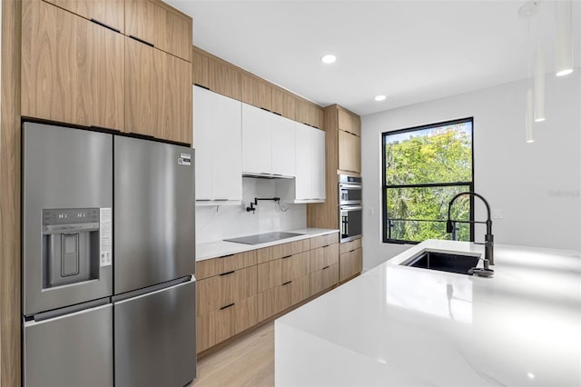 kitchen with modern cabinets, white cabinetry, stainless steel appliances, and light countertops