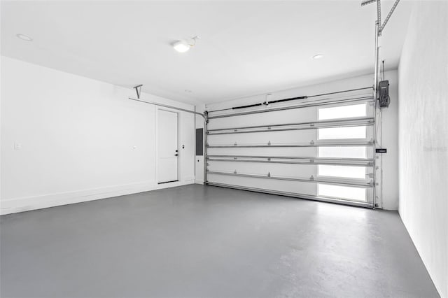 garage featuring electric panel and baseboards