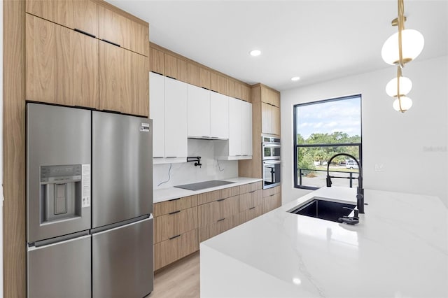 kitchen featuring stainless steel appliances, modern cabinets, white cabinets, and a sink