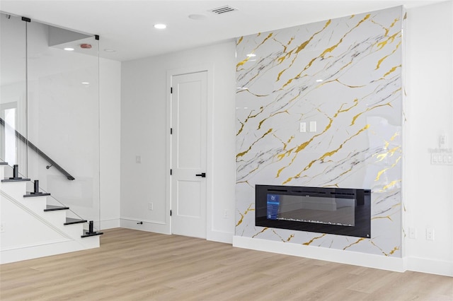 interior space featuring visible vents, wood finished floors, stairs, a fireplace, and recessed lighting