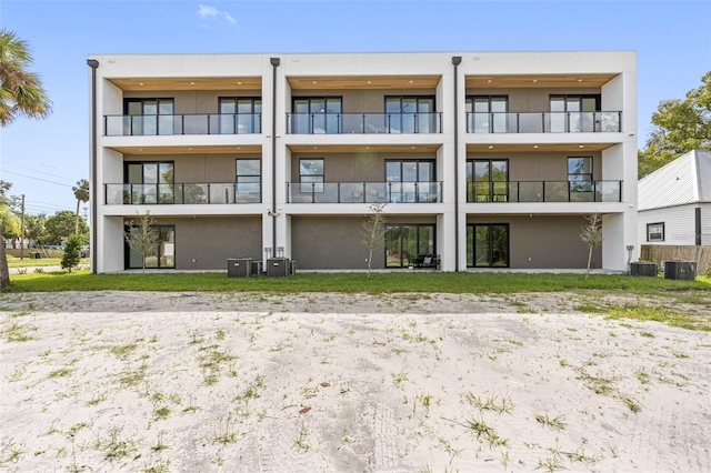 back of property featuring central AC and stucco siding