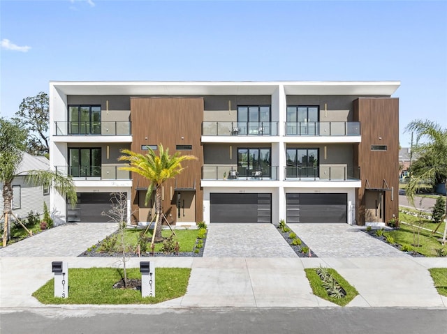 view of front of home featuring a garage, decorative driveway, and stucco siding