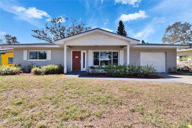 ranch-style home with an attached garage, a front yard, concrete driveway, and stucco siding