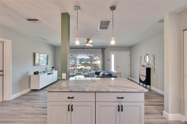 kitchen with white cabinetry, visible vents, open floor plan, and pendant lighting