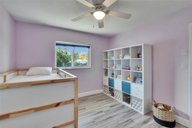 bedroom with baseboards, ceiling fan, and light wood-style floors