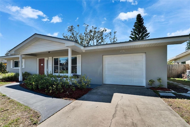 single story home with concrete driveway, an attached garage, and stucco siding