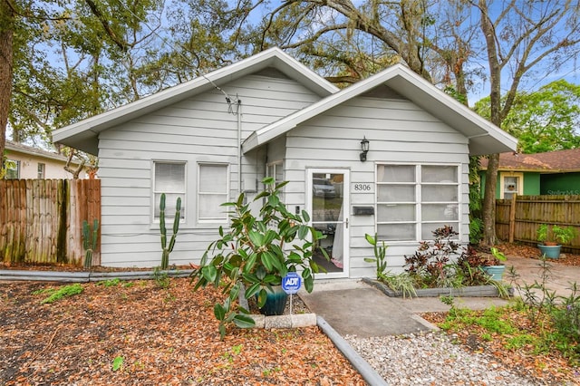 bungalow-style home with fence