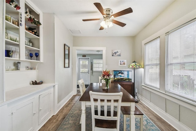 dining space with a ceiling fan, visible vents, dark wood finished floors, and baseboards