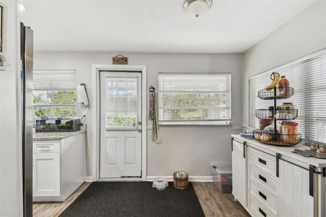 entryway featuring baseboards and wood finished floors