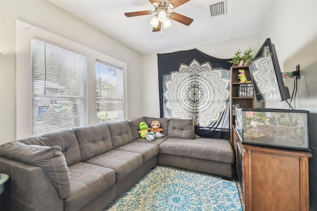 living area featuring a ceiling fan and visible vents