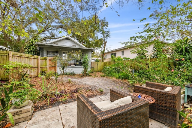 back of property with fence, a porch, and a patio