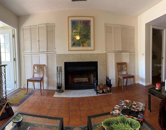 sitting room with tile patterned flooring, a fireplace with flush hearth, visible vents, and baseboards