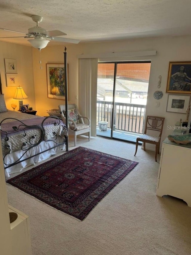 living area with carpet, ceiling fan, and a textured ceiling