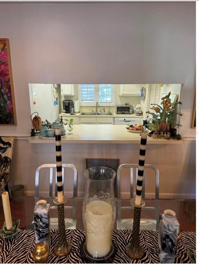 kitchen with light countertops, a sink, and freestanding refrigerator