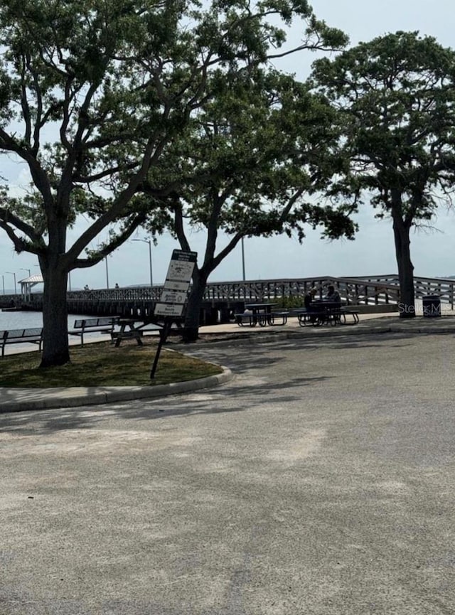 view of street featuring a water view and curbs