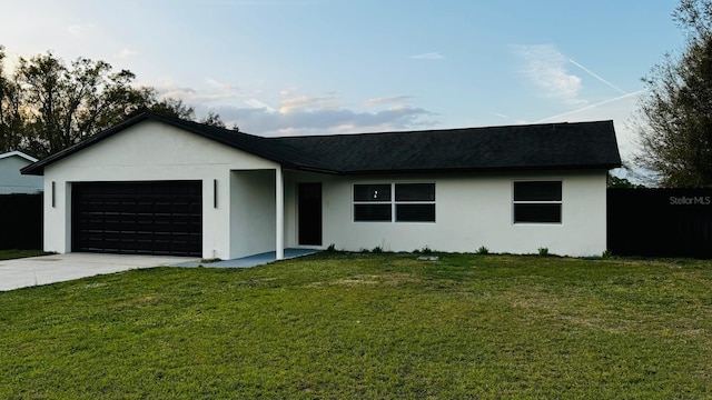 single story home with a garage, driveway, a front yard, and stucco siding