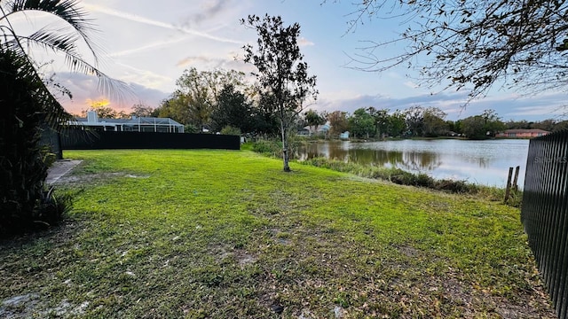 view of yard featuring a water view and fence