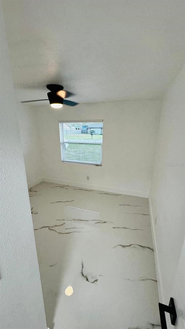 unfurnished room with baseboards and a textured ceiling