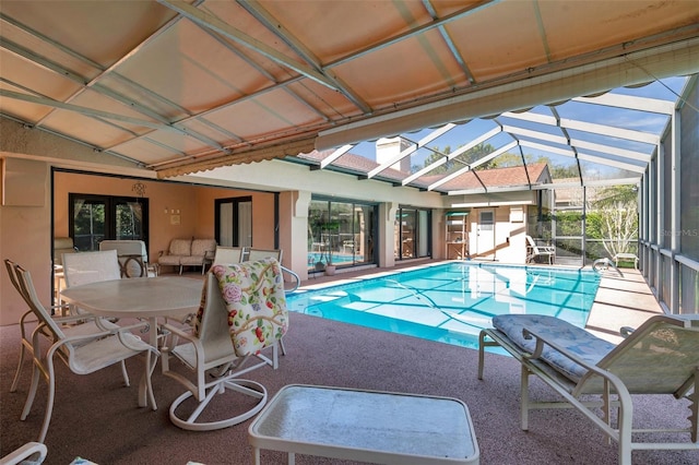 outdoor pool with outdoor dining space, a lanai, and a patio area