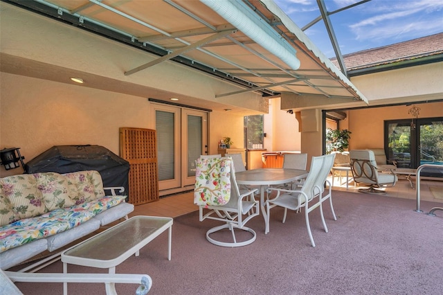 view of patio featuring outdoor dining area, french doors, and a lanai