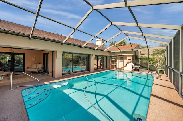 outdoor pool with a lanai and a patio area