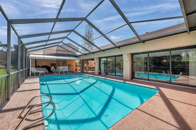 pool featuring glass enclosure and a patio area