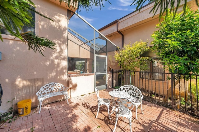 view of patio with a lanai and fence