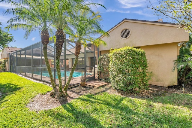 outdoor pool with glass enclosure and a yard