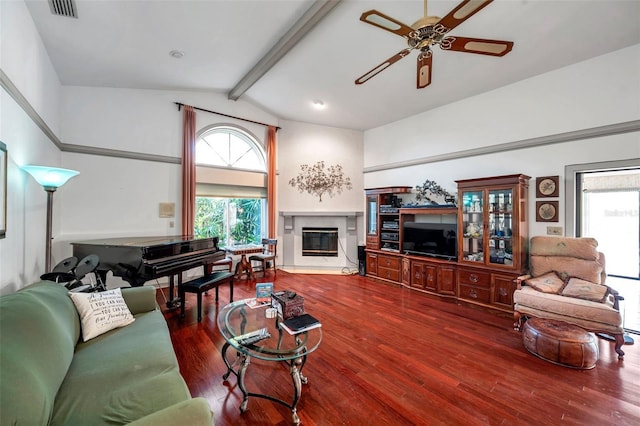 living area with vaulted ceiling with beams, ceiling fan, a fireplace, wood finished floors, and visible vents