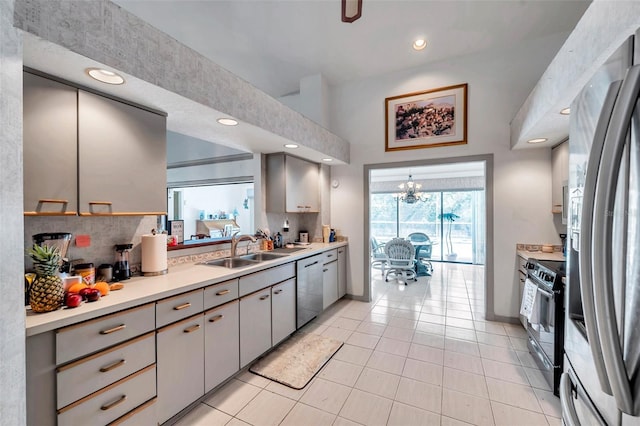 kitchen with stainless steel appliances, light countertops, a sink, and backsplash