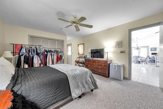 bedroom with refrigerator, a closet, a ceiling fan, light carpet, and light tile patterned flooring