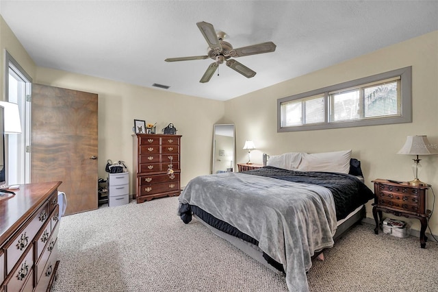 carpeted bedroom with visible vents, arched walkways, and a ceiling fan