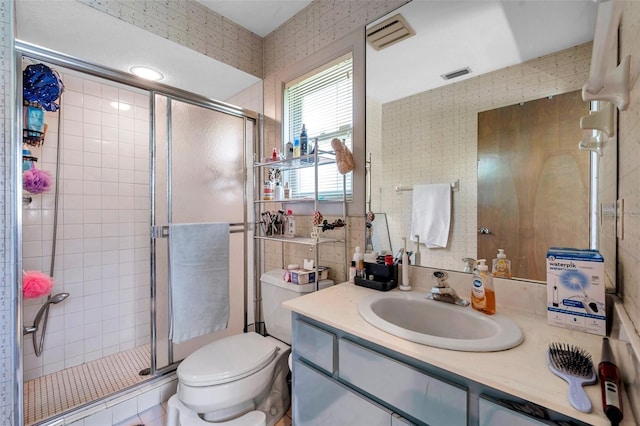 full bath featuring toilet, vanity, a shower stall, and visible vents