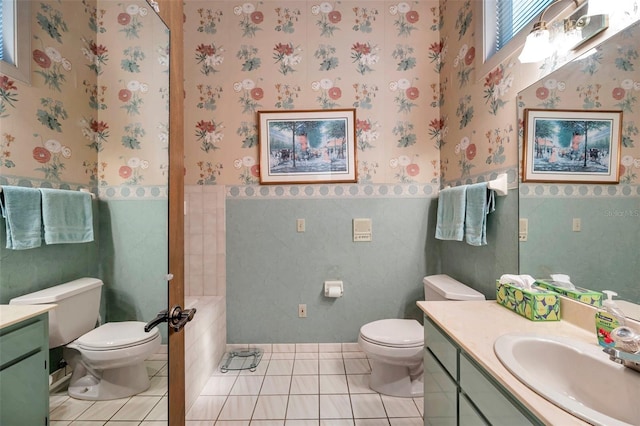 bathroom with wainscoting, vanity, toilet, and wallpapered walls