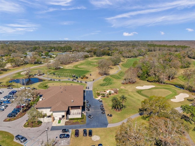 birds eye view of property with view of golf course and a water view