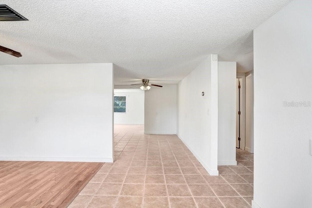 unfurnished room with visible vents, ceiling fan, and a textured ceiling