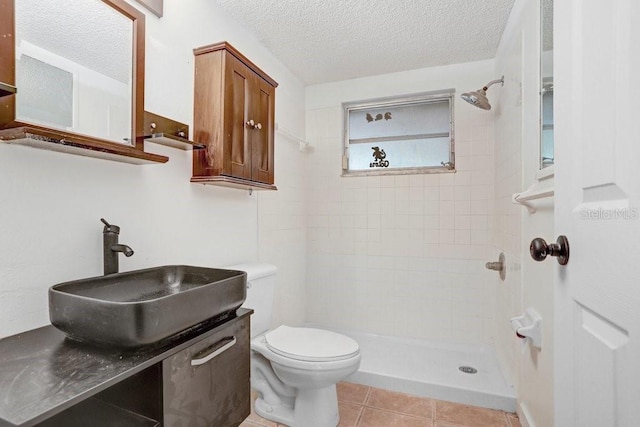 full bathroom with a textured ceiling, a sink, toilet, and a shower stall