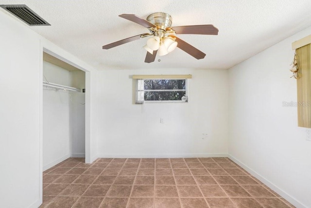 unfurnished bedroom featuring ceiling fan, a textured ceiling, visible vents, and a closet