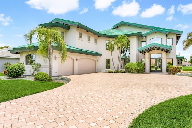 view of front facade with stucco siding, decorative driveway, and french doors