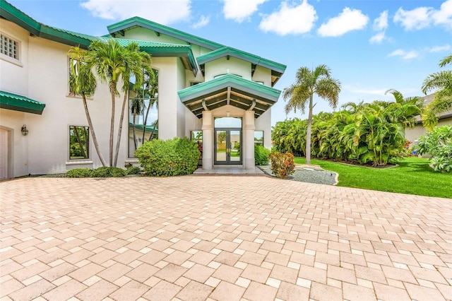 property entrance featuring stucco siding and french doors