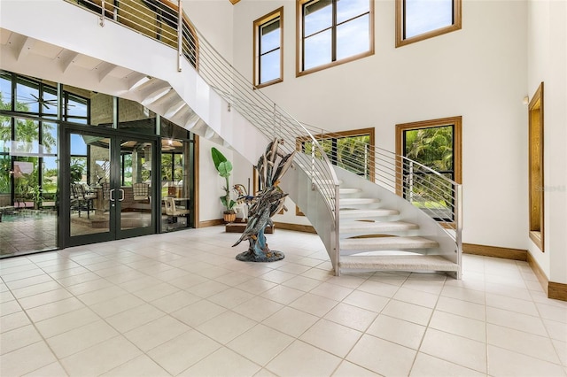 stairway with baseboards, plenty of natural light, and tile patterned floors