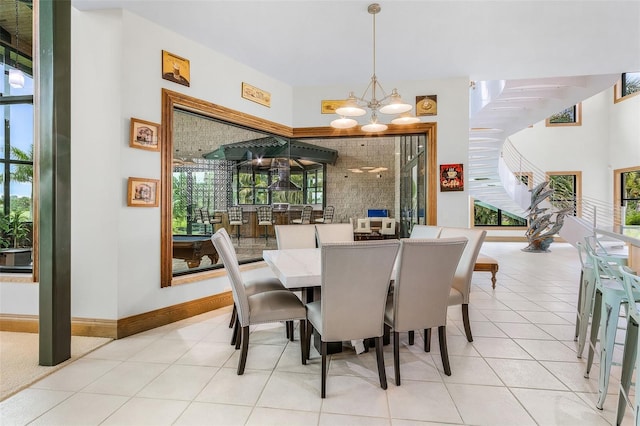 dining space with a chandelier, light tile patterned floors, and baseboards