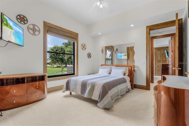 bedroom featuring ceiling fan, baseboards, and light colored carpet