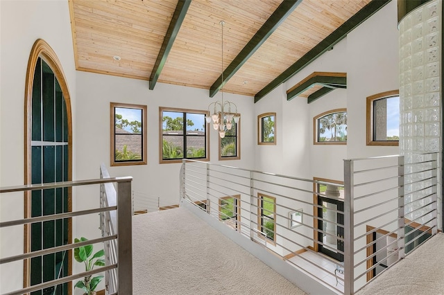 hallway with lofted ceiling with beams, carpet floors, wood ceiling, and an inviting chandelier